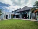 Modern house exterior with large windows and lawn