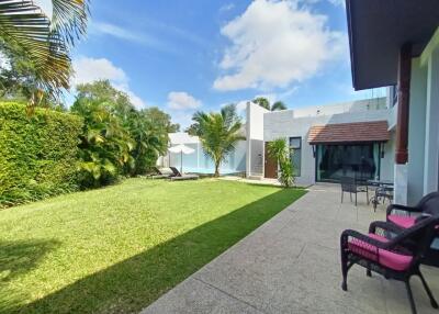 Spacious backyard with patio seating and lush greenery