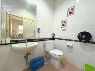 Clean bathroom with white tiles and a wall-mounted sink