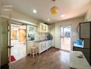 Modern kitchen with white cabinets, wood flooring, and ample lighting