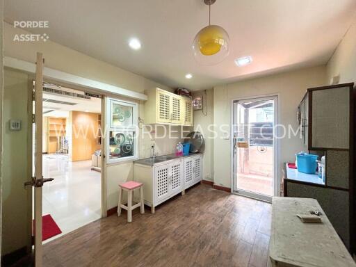 Modern kitchen with white cabinets, wood flooring, and ample lighting