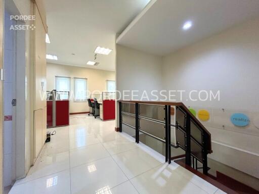 modern office space with bright lighting and railing overlooking a stairwell