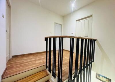 Upper floor landing area with wooden floors and railing