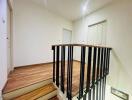 Upper floor landing area with wooden floors and railing