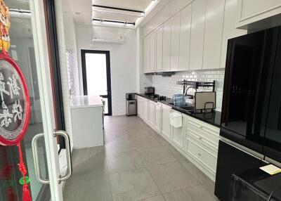 Modern kitchen with white cabinets and black appliances