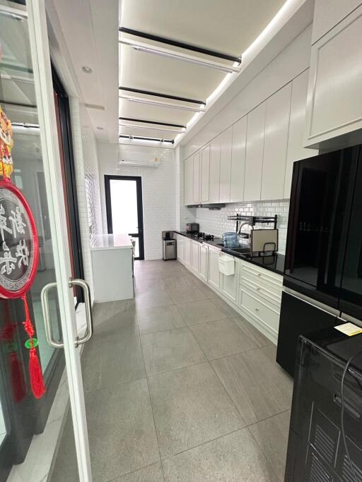 Modern kitchen with white cabinets and black appliances