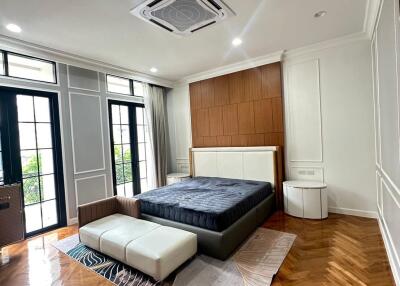 Spacious bedroom with modern furnishings and a wooden herringbone floor