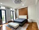 Spacious bedroom with modern furnishings and a wooden herringbone floor