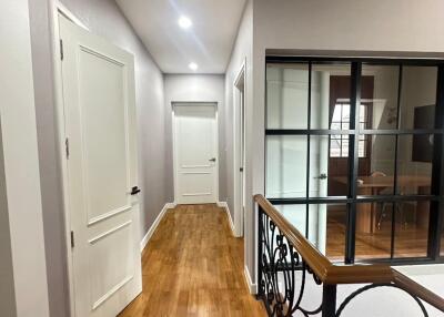 Bright hallway with wooden floor and ornamental railing