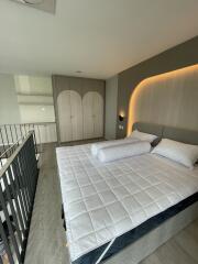 Modern bedroom with large bed, built-in wardrobe, and ambient lighting