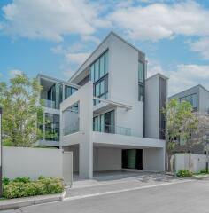 Modern multi-story residential building with large windows and private balconies