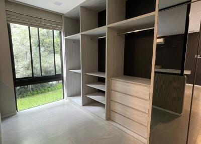 Spacious bedroom with built-in shelving and large windows