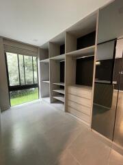 Spacious bedroom with built-in shelving and large windows