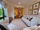 Well-lit living room with white sofa and framed pictures on the wall