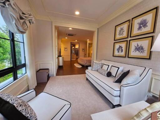 Well-lit living room with white sofa and framed pictures on the wall