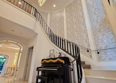 Elegant staircase with chandelier and piano