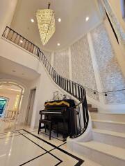 Elegant staircase with chandelier and piano