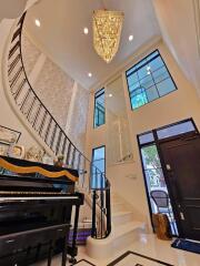 Elegant main living space with a grand staircase and chandelier