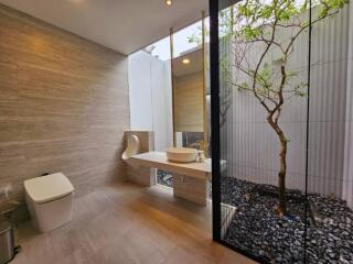 Modern bathroom with large window and natural elements