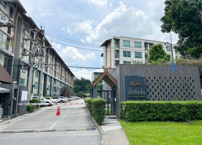 Entrance of a residential complex with buildings in the background