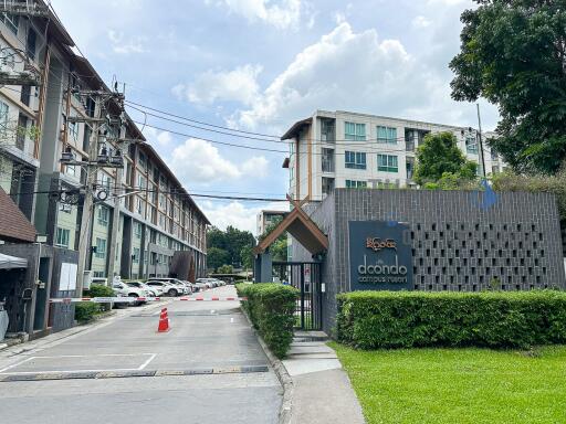 Entrance of a residential complex with buildings in the background