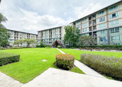 exterior view of multi-story apartment buildings with green lawn