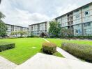 exterior view of multi-story apartment buildings with green lawn