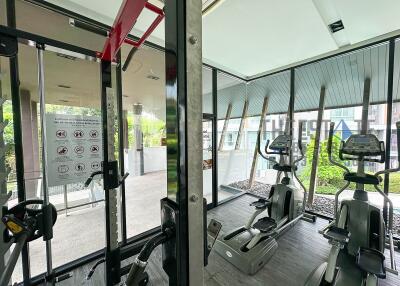 Residential gym with fitness equipment and large windows