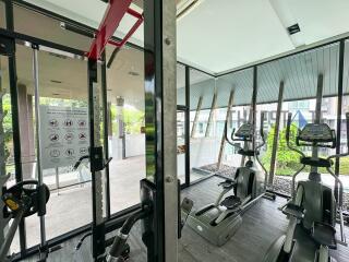 Residential gym with fitness equipment and large windows