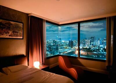 Nighttime city view from a cozy bedroom with modern furnishings