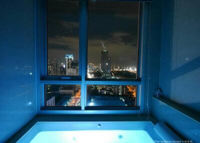 Bathroom with a large window and night city view