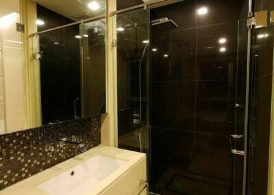 Modern bathroom with glass shower, vanity, and large mirror