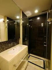 Modern bathroom with glass shower, vanity, and large mirror