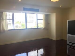 Spacious living room with large windows and wooden floor