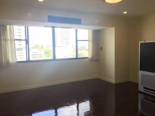 Spacious living room with large windows and wooden floor