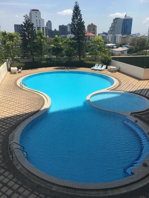 Outdoor swimming pool area with city skyline