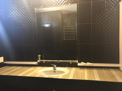 Modern bathroom with black tiled walls