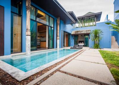 Outdoor view of modern residential building with private pool and sun loungers