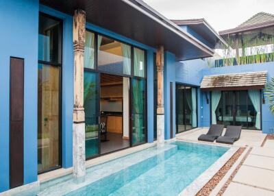 Outdoor pool area with sun loungers and modern blue facades