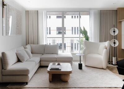 Spacious and modern living room with white L-shaped sofa and large windows