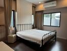 Spacious bedroom with metal frame bed and large windows