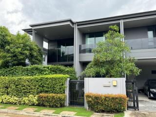 Modern two-story house with a well-maintained garden and driveway