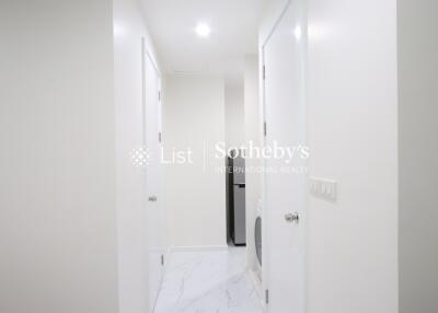 Bright hallway with white doors and marble flooring