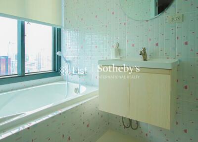 Bathroom with bathtub, sink, and large window