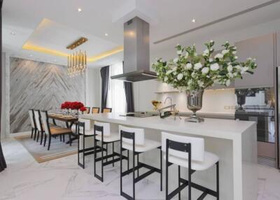 Modern kitchen and dining area with island, bar stools, and floral decorations