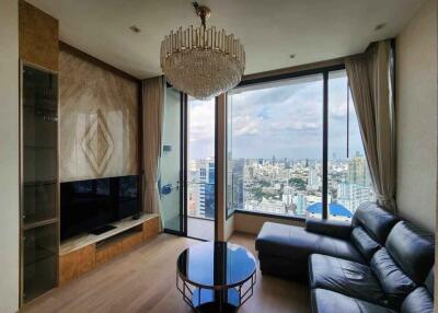 Modern living room with a chandelier, large windows, and city view