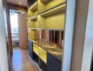 Narrow hallway with built-in shelving, wooden flooring and ambient lighting