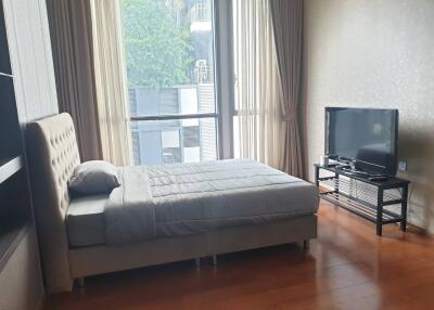 Modern bedroom with large windows and a TV