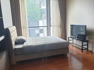 Modern bedroom with large windows and a TV