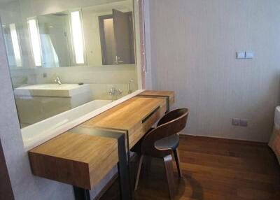 Modern bedroom with a wooden desk and chair next to an attached bathroom